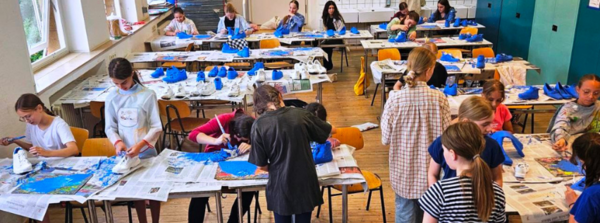Eine Schulklasse beim Bemalen der Schuhe