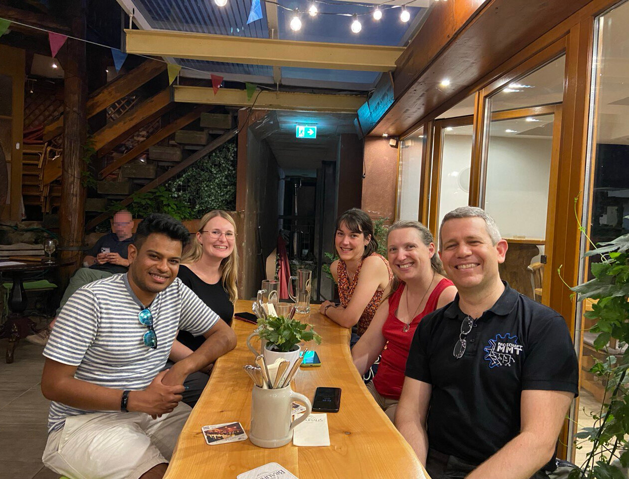 Gruppenmitglieder sitzen gemeinsam am Tisch