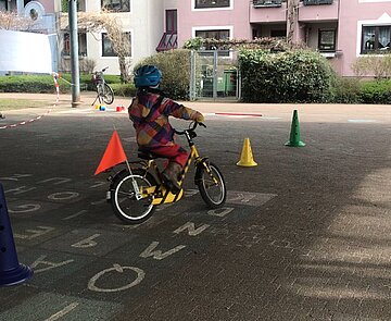 Kind auf Fahrrad fährt einen Parcour