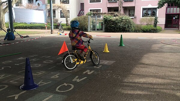 Kind auf Fahrrad fährt einen Parcour