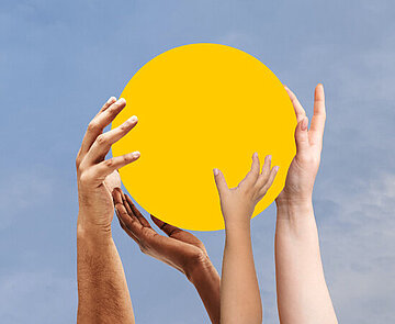 Verschiedene Hände halten eine gelbe Sphäre hoch in den Himmel