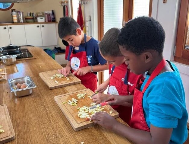 Gruppe von Kindern bereitet Essen zu 