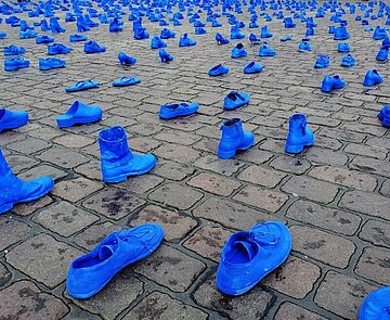 Blau bemalte Schuhe auf dem Boden