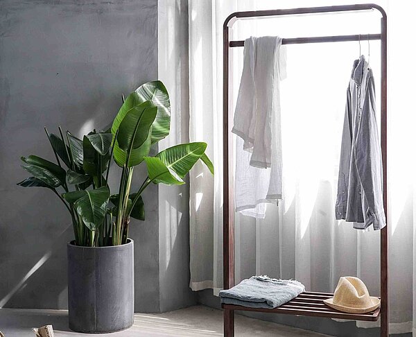 An einer Kleiderstange hängen ein paar Kleidstücke.