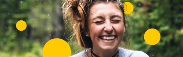 Frau im Wald mit Schmuck, lachend, mit gelben Sphären um sie herum