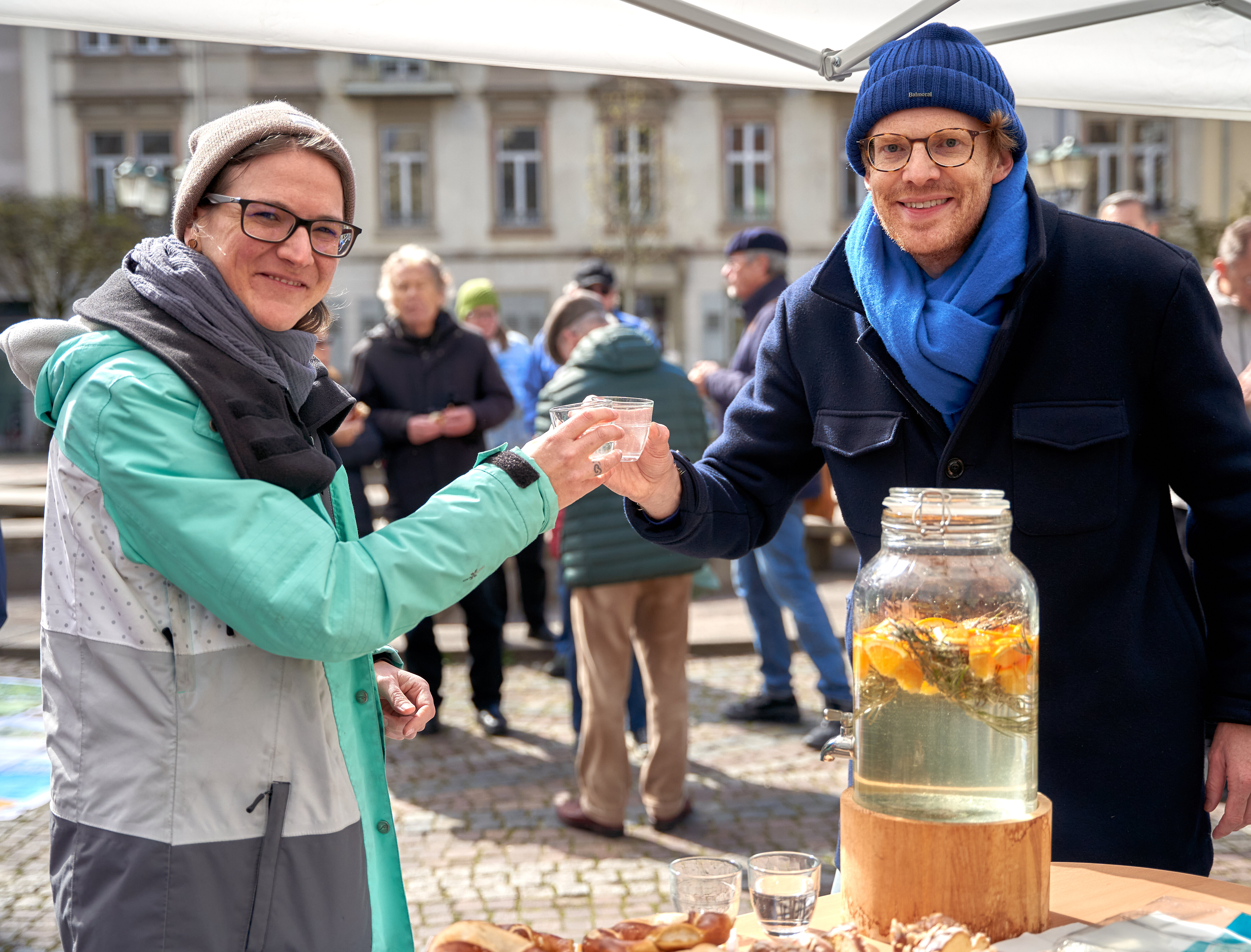 Zwei Personen prosten sich mit Wasser zu 