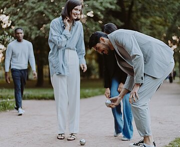 Eine Gruppe Menschen spielt gemeinsam Boule.