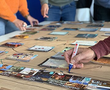 Nahaufnahme eines Tischs mit Puzzleteilen und Mindmaps im Hintergrund