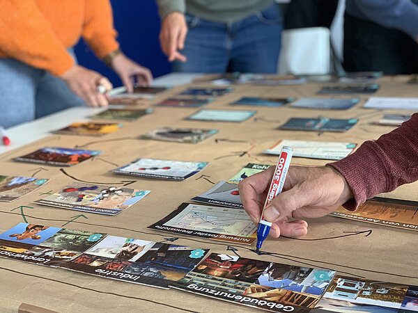 Nahaufnahme eines Tischs mit Puzzleteilen und Mindmaps im Hintergrund