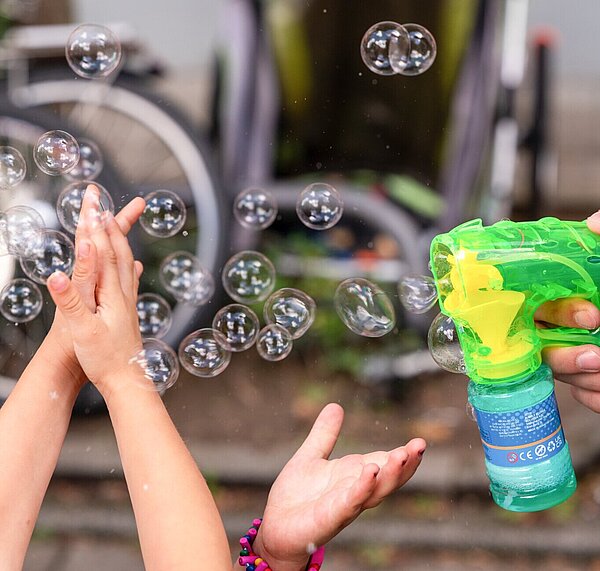 Kinder spielen mit Seifenblasen