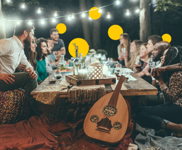Leute um einen Tisch, draußen, Bild versehen mit gelben Sphären