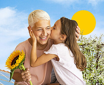 Ältere, weiblich gelesene Person mit Sonnenblume in der Hand, wird von Kind auf die Wange geküsst. Im Hintergrund sieht man ein Dach mit Solaranlagen. Oben ist eine grafisch dargestellte Sonne.