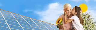Ältere, weiblich gelesene Person mit Sonnenblume in der Hand, wird von Kind auf die Wange geküsst. Im Hintergrund sieht man ein Dach mit Solaranlagen. Oben ist eine grafisch dargestellte Sonne.