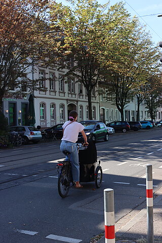 Frau, die mit Lastenrad durch Karlsruhe radelt