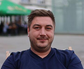 Porträt von Dominik Meitzler: junger Mann in Liegestuhl sitzend auf Karlsruher Marktplatz