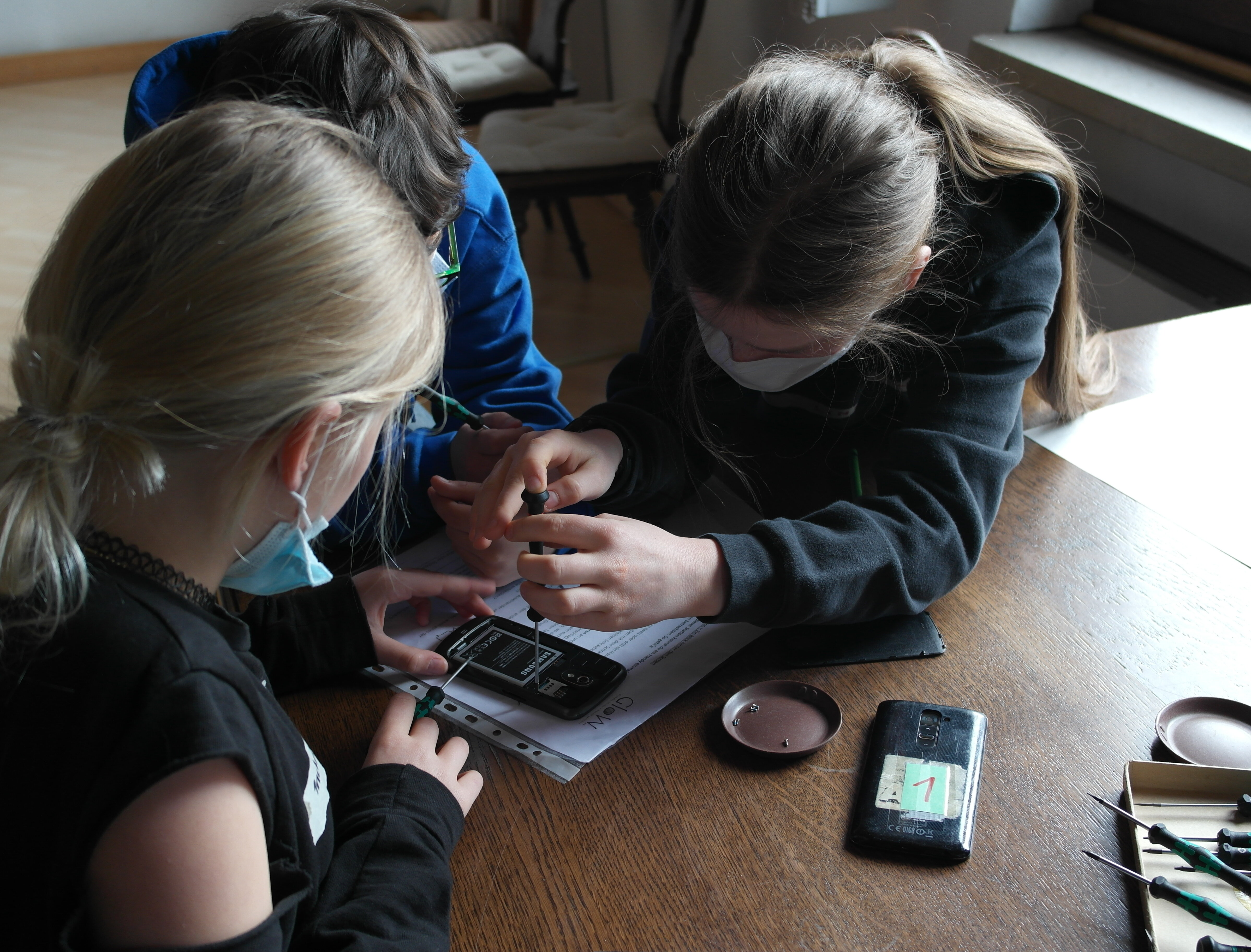  Elektronikworkshop in einer Schulklasse, durchgeführt vom GloW Karlsruhe e.V., 3 Schülerinnen reparieren ein Smartphone